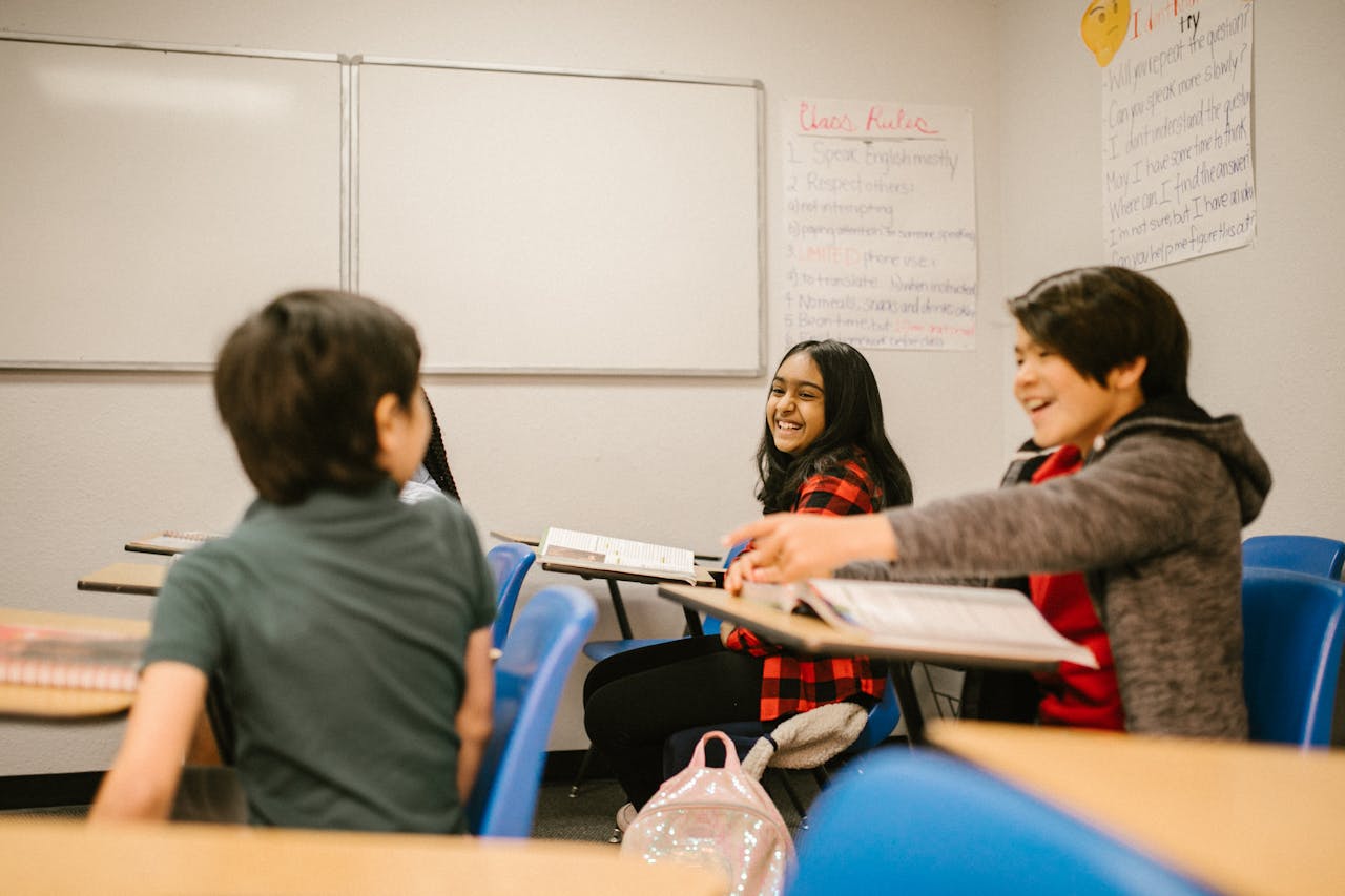 Happy students interacting and laughing together in a classroom environment.