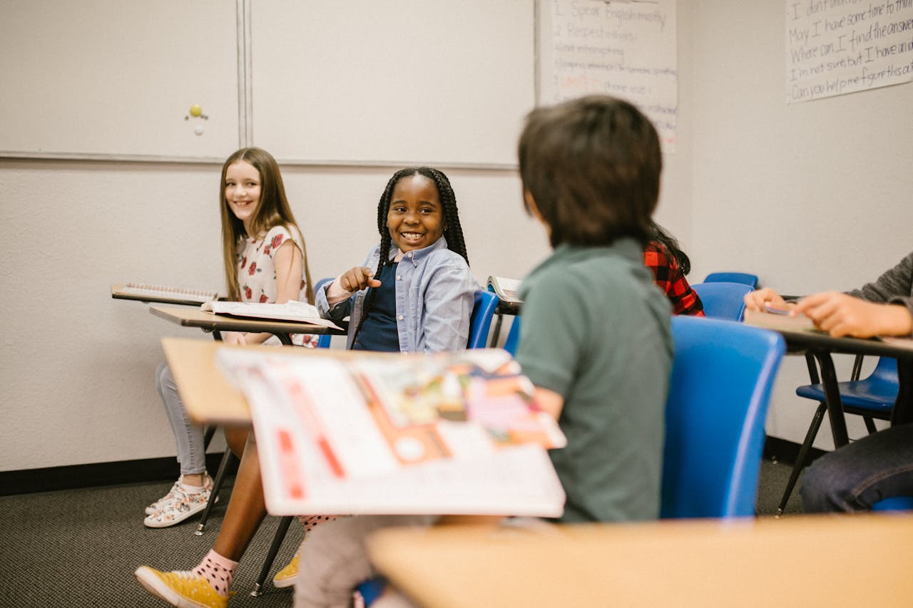 Group of diverse children smiling and engaging in a classroom setting.