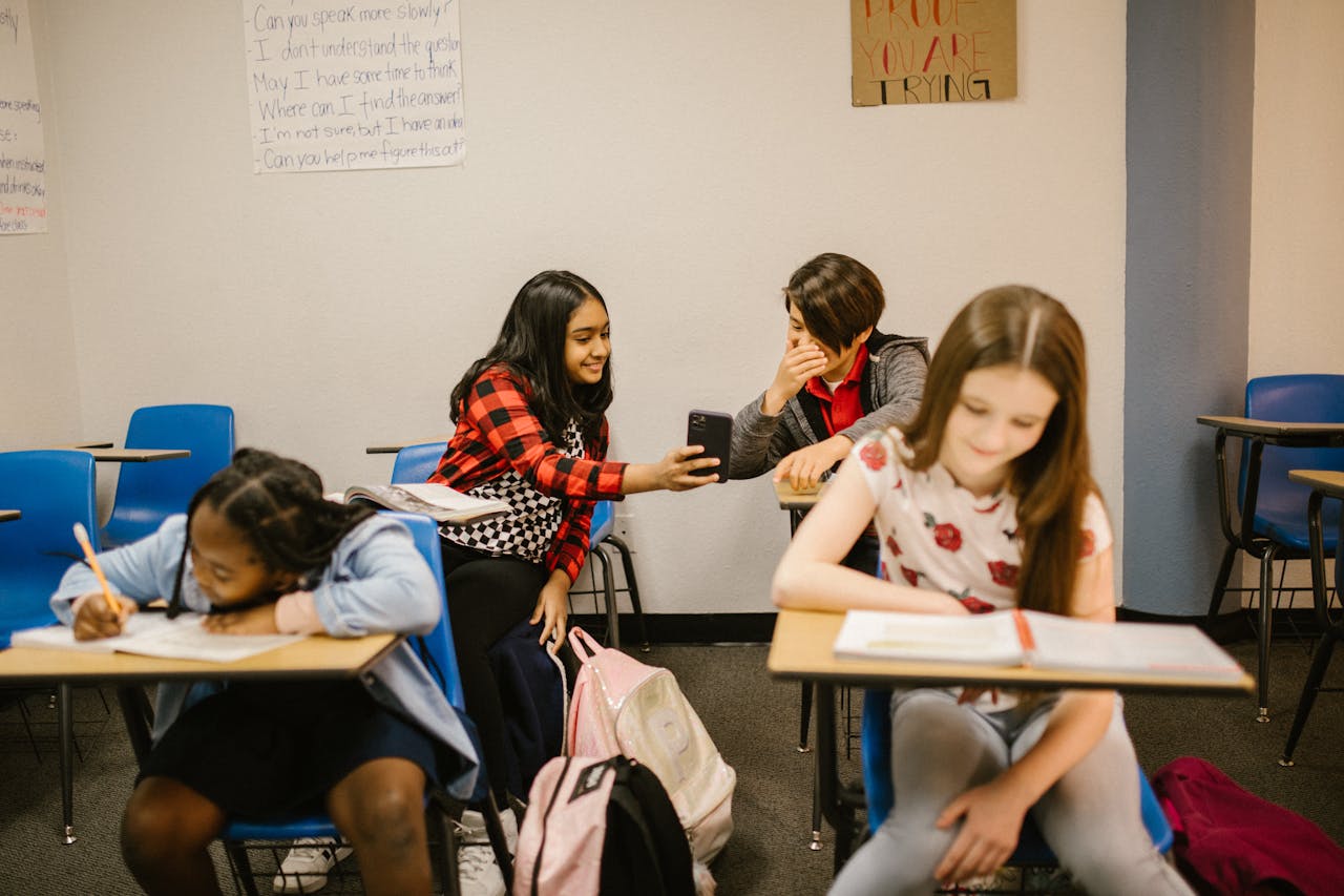 A diverse group of children interacting and studying in a school classroom.